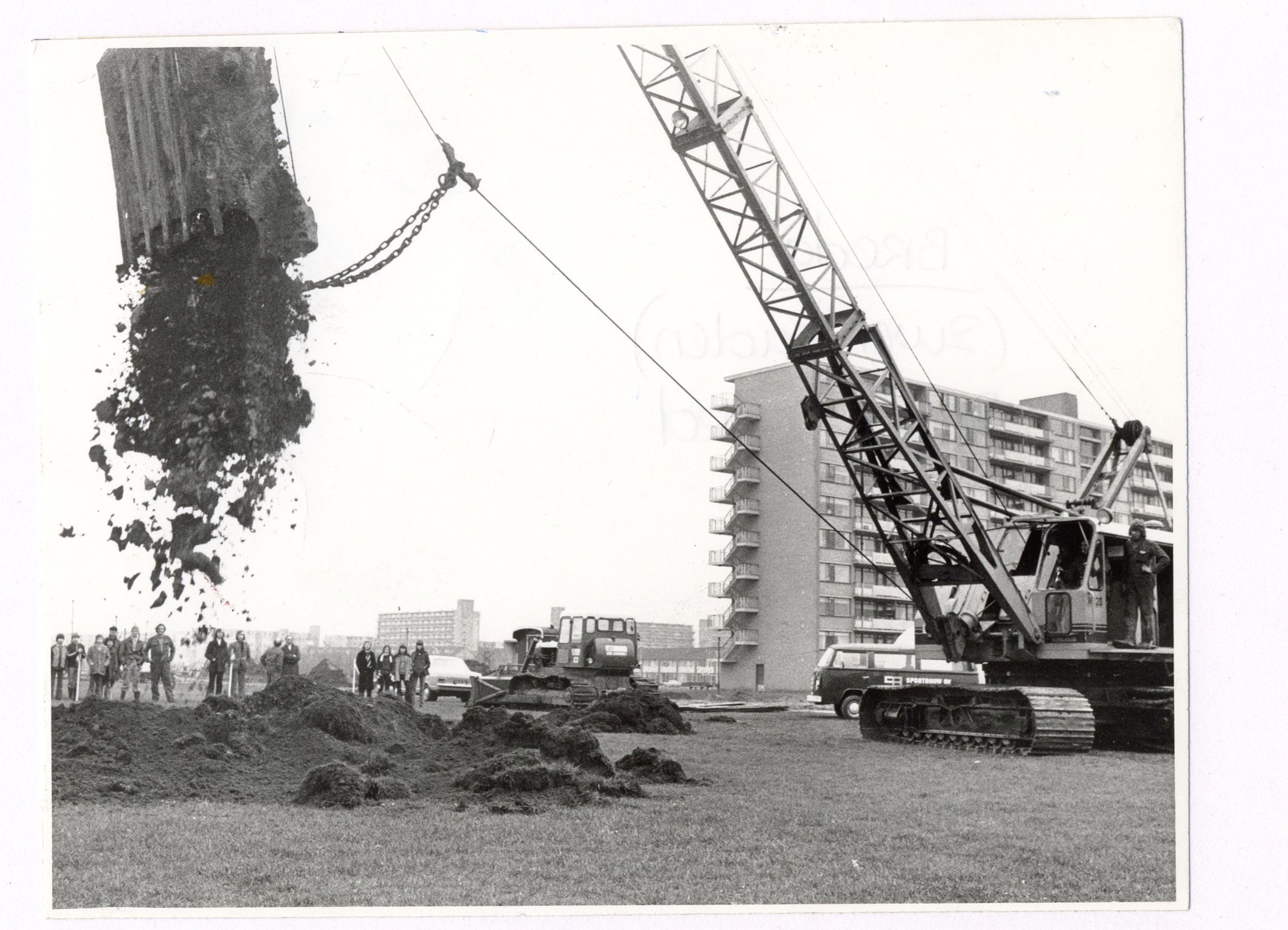 Wethouder J. Mans doet met hijskraan de eerste grondverplaatsing voor de bouw van zwembad De Wisselslag 1974